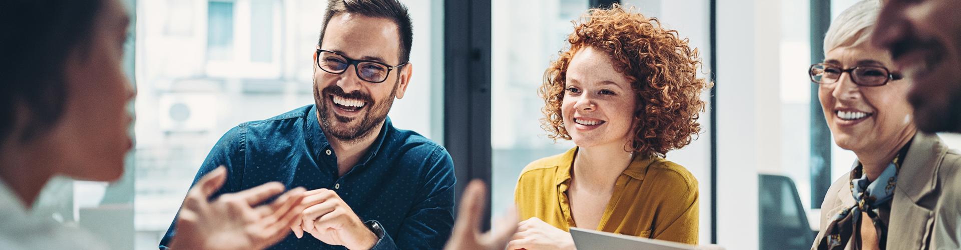 Gens souriants rassemblés autour d'un travail de recherche