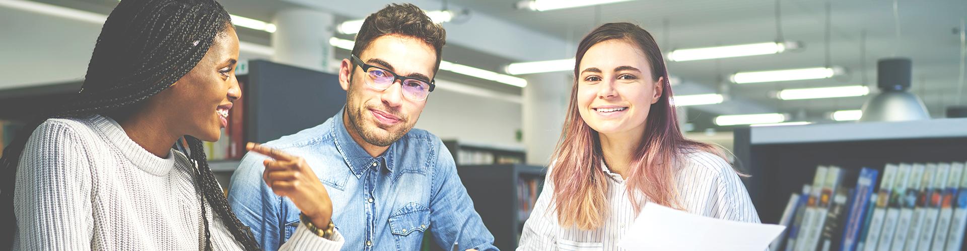 Étudiantes et étudiants souriants faisant un travail d'équipe